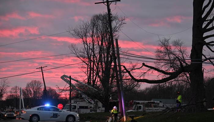 Utility workers repair electric lines at dusk, the day after a tornado hit Sullivan, Indiana, US, April 1, 2023. — Reuters