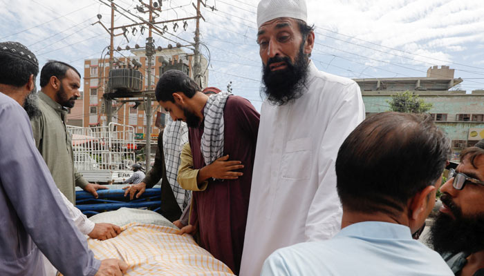 Umer Zada, father of seven-year-old Saad Umer, who was killed with others in a stampede during handout distribution, mourns the death of his son during the funeral in Karachi on April 1, 2023. — Reuters