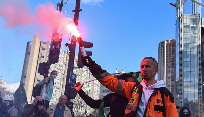 French rail operator SNCF workers hold a red flare during a demonstration at Place d´Italie, on the 11th day of action after the government pushed a pensions reform through parliament without a vote, using article 49.3 of the constitution, in Paris on April 6, 2023.—AFP