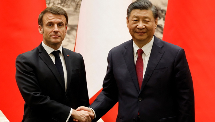 Chinas President Xi Jinping (R) shakes hands with his French counterpart Emmanuel Macron after the signing ceremony in Beijing on April 6, 2023. — AFP