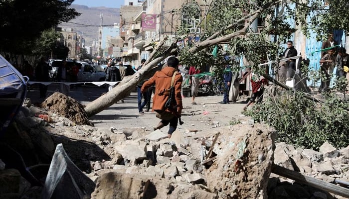 An armed man walks at the site of a Saudi-led air strike in Sanaa, Yemen. — Reuters/File