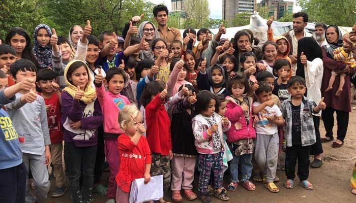 Family poses with children and community members in Pakistan. — Photo by correspondent