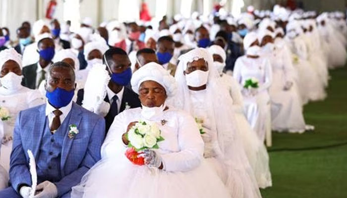 A bride and a groom wait during the Easter Sunday mass wedding ceremony, organised by the International Pentecostal Holiness Church Jerusalem City (IPHC), with more than 800 couples taking part, in Kgabalatsane in the North-West province, South Africa, April 9, 2023. —Reuters