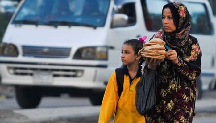 A woman carrying bread walks her daughter to school in the Giza suburb of Awsim, Egypt October 10, 2021. —Reuters