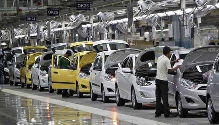 Workers assemble cars inside an automobile manufacturing plant on October 4, 2012. — Reuters/File