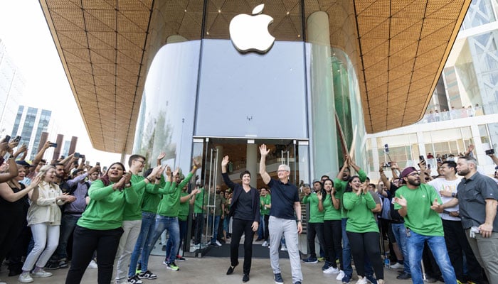 Apple CEO Tim Cook ( waving on right) and Apples Senior Vice President of Retail Deirdre OBrien wave in front of the open doors at Apple BKC, surrounded by team members and customers on April 18, 2023. — Twitter/Tim_Cook