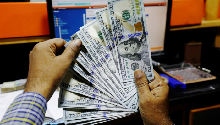 A trader shows US dollar notes at a currency exchange booth in Karachi, December 23, 2018. — Reuters