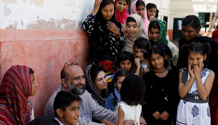 Faisal Edhi and his wife Saba Edhi sit with children taking shelter at the Edhi Home Orphanage Centre in Karachi on April 17, 2023. — Reuters