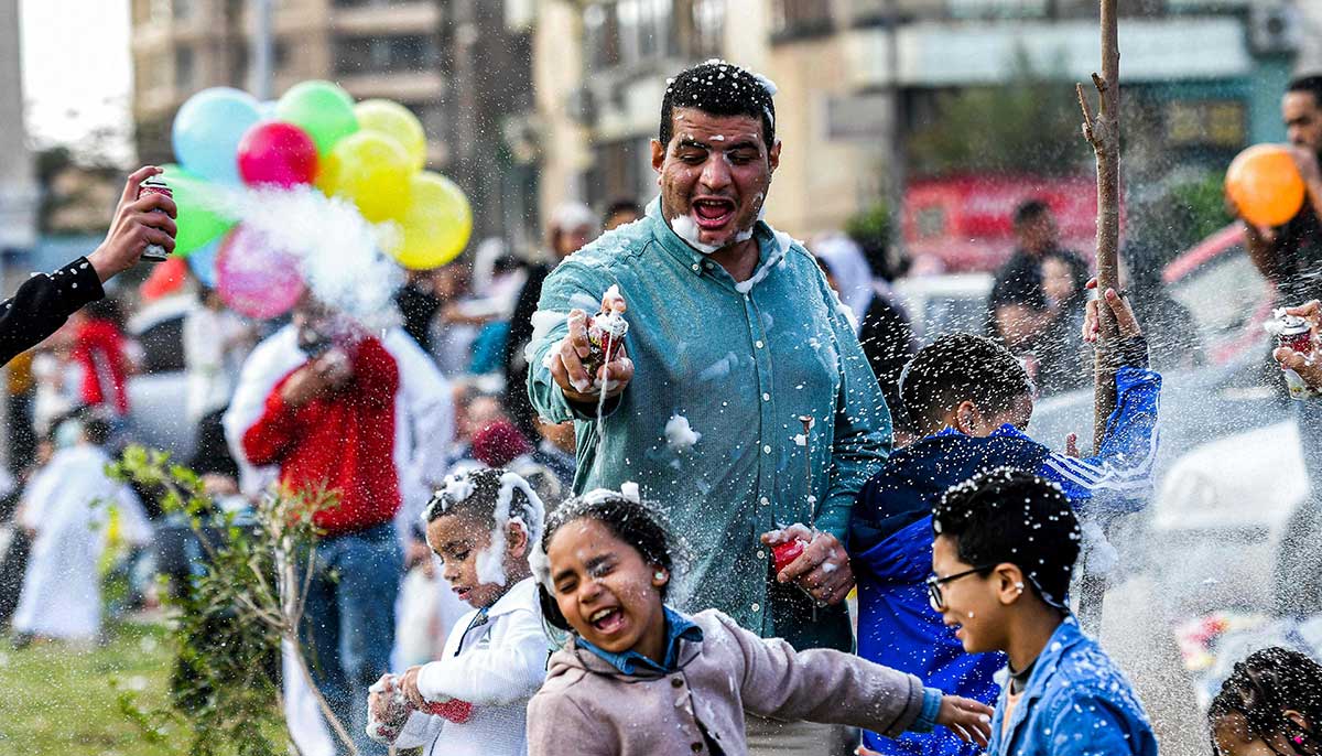 Revellers spray foam at each other after prayers on the first day of Eid ul Fitr outside Egypts Al-Seddiq Mosque in Cairo on April 21, 2023.