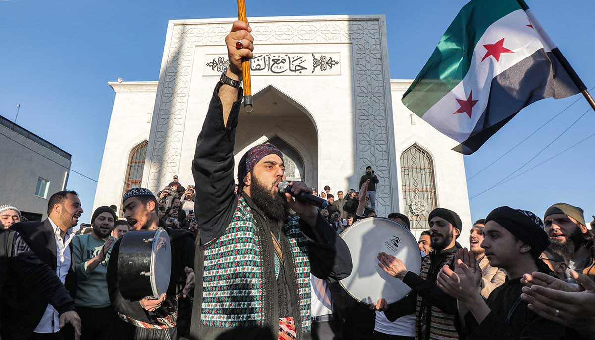 Performers in traditional costumes gather for a celebration of Eid ul Fitr in the square outside the Mohamed al-Fatih mosque in Syrias rebel-held city of al-Bab (which was heavily affected by the destructive February 6 earthquake) on April 21, 2023.