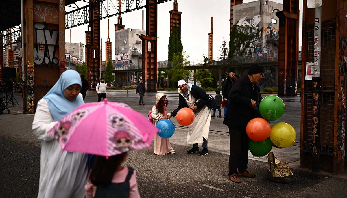 Worshippers arrive to attend a morning prayer on the first day of Eid ul Fitr at the industrial wasteland of Parco Dora in Turin on April 21, 2023.