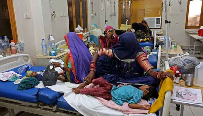 Internally displaced people take care of their children under treatment for malaria and gastro in the flood-hit Hyderabad city of Sindh province on September 11, 2022. — AFP