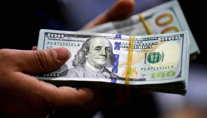 An undated image of a currency dealer holding a stack of $100 notes. — AFP/File