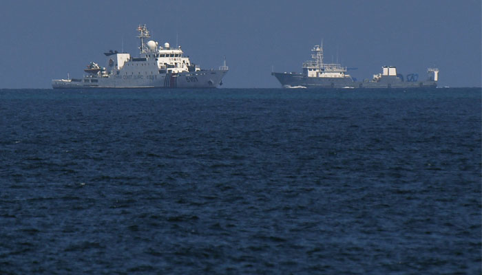 A Chinese coast guard vessel sailing past a Chinese vessel near the Philippine-occupied Thitu island in the disputed South China Sea. — AFP/File