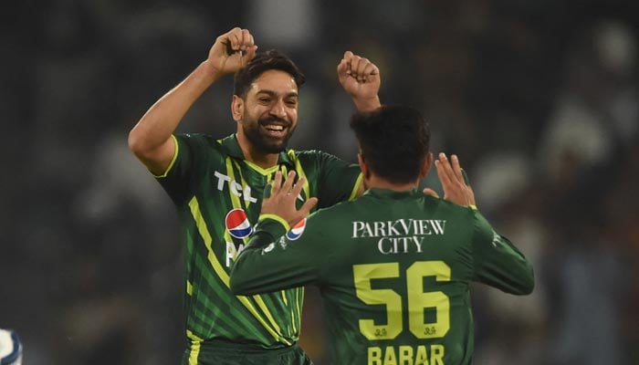 Pakistans Haris Rauf (L) celebrates with Babar Azam (R) the wicket of New Zealand Daryl Mitchell (not pictured) during the second T20 cricket match between Pakistan and New Zealand at the Gaddafi Cricket Stadium in Lahore on April 15, 2023. — AFP