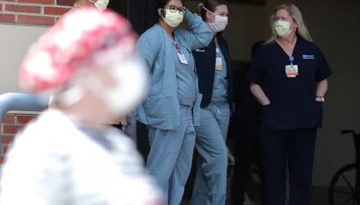 Nurses stand in a hospital doorway watching a nurses’ protest for personal protective equipment at UCLA Medical Center, as the spread of the coronavirus disease (COVID-19) continues, in Los Angeles, California, U.S., April 13, 2020. —Reuters