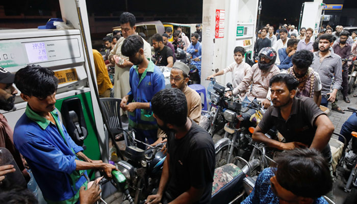 People wait their turn to get fuel at a petrol station, in Karachi, on June 2, 2022. — Reuters