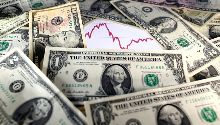 US dollar notes are seen in front of a stock graph in this file photo. — Reuters