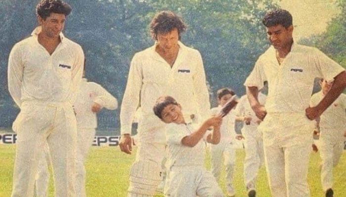 Wasim Akram (L), Imran Khan (Center) and Waqar Younis (R) look down at a child. Photo: Imran Khan Instagram account