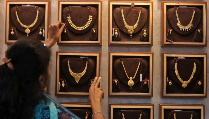 A saleswoman shows a gold necklace to a customer at a jewellery showroom during Dhanteras, a Hindu festival, in Indias Mumbai on October 22, 2022. — Reuters/File