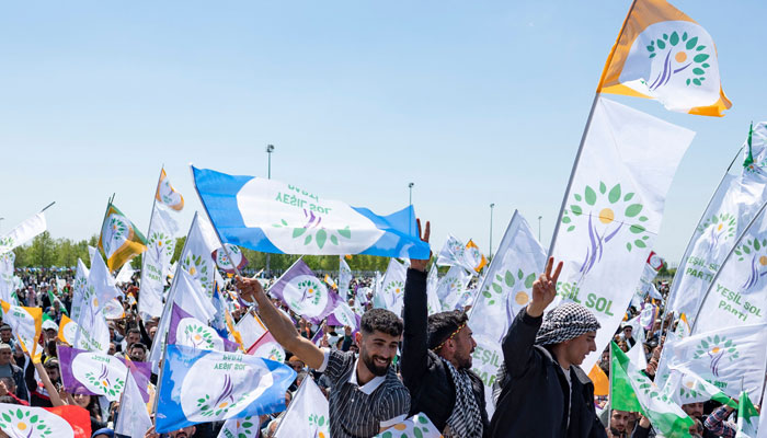 Supporters of the Green Left Party (YSP) wave flags and cheer during a campaign rally in Istanbul, on May 13, 2023. — AFP