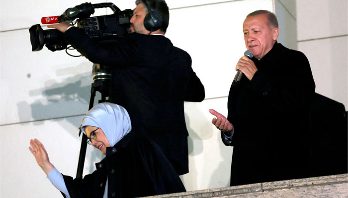 Turkish President Tayyip Erdogan (R) addresses supporters with his wife Ermine Erdogan (L) at the AK Party headquarters after polls closed in Turkey. — AFP