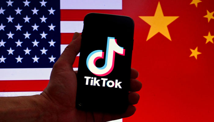 This photo shows the TikTok logo displayed on the screen of an iPhone in front of a US and Chinese flag in Washington, DC. — AFP/File