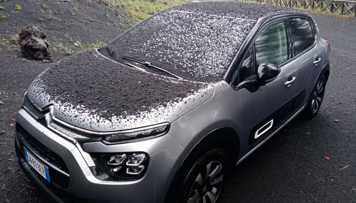 A car can be seen covered with dark ashes as a result of a volcano shower on 21 May 2023. — Twitter/@etnaboris