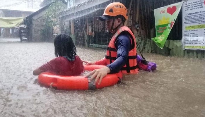 A Coast Guard personnel can be seen assisting a resident in their evacuation due to flooding caused by Typhoon. — Reuters/File