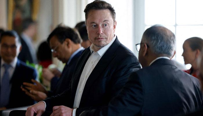 Tesla and SpaceX CEO Elon Musk talks to another CEO before a roundtable during the 6th edition of the Choose France Summit at the Chateau de Versailles, outside Paris on May 15, 2023. — AFP