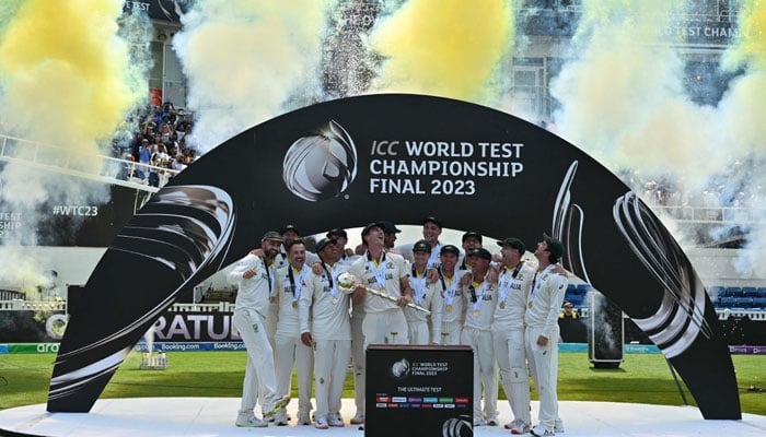 Australia´s Pat Cummins (C/L) lifts the ICC Test Championship Mace as he celebrates with teammates after victory in the ICC World Test Championship cricket final match between Australia and India at The Oval, in London, on June 11, 2023. — AFP