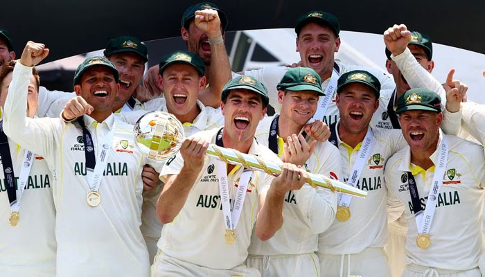 Australias Pat Cummins celebrates with the ICC Test Mace on the podium along with teammates after winning the World Test Championship final.—Reuters