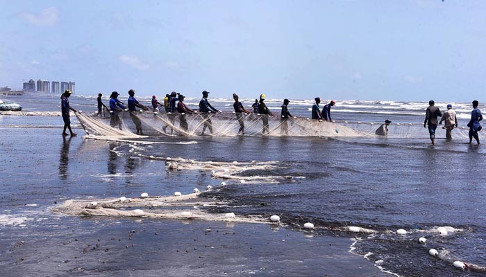 Fishermen throwing a net into the sea for catching fish at sea view on May 31, 2023. — APP