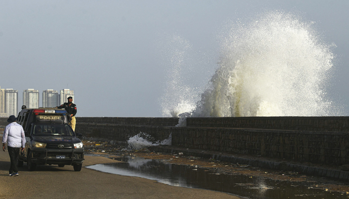 A police vehicle patrols a beach before the due onset of Biparjoy in Karachi on June 12, 2023. — AFP