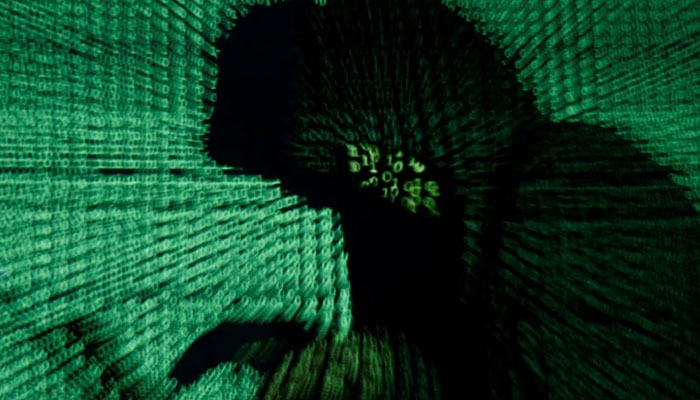 A man holds a laptop computer as cyber code is projected on him in this illustration picture. — Reuters/File