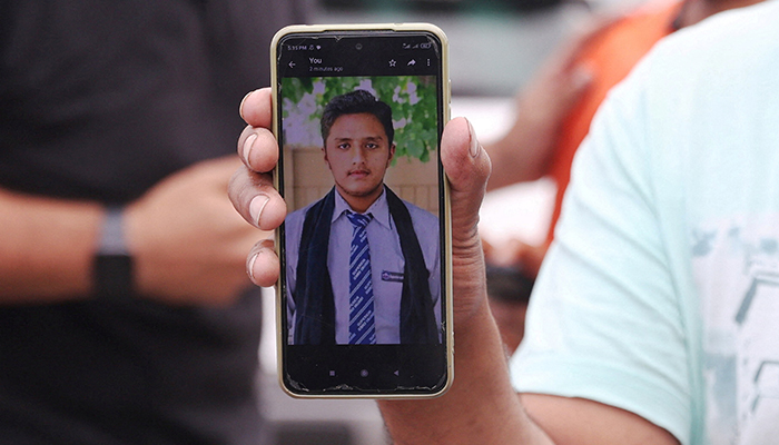 Pakistani Hassan Ali, who says his brother Fahad, 21, was onboard a boat with migrants that capsized at open sea off Greece, shows a photo of his brother in front of a migrant camp in Malakasa, near Athens, Greece, June 16, 2023. — Reuters