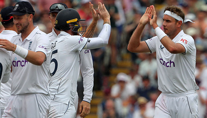 England´s Stuart Broad (R) celebrates with teammates after taking the wicket of Australia´s Scott Boland on day three of the first Ashes cricket Test match between England and Australia at Edgbaston in Birmingham, central England on June 18, 2023.—AFP