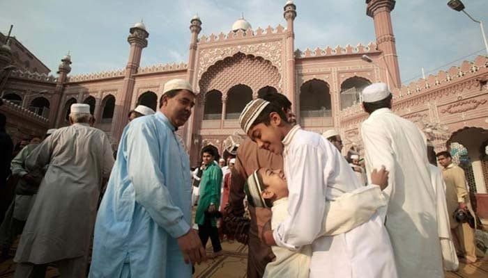 عید کے تہوار کے موقع پر ایک دوسرے کو گلے لگاتے ہوئے لوگوں کی ایک نمائندہ تصویر۔  — اے ایف پی/فائل
