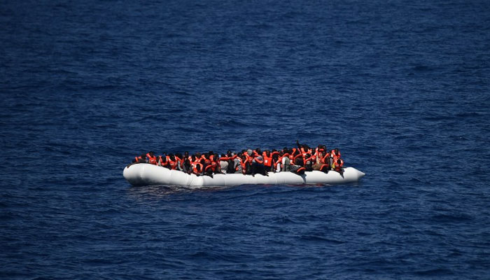 This picture shows refugees waiting on a rubber boat to be rescued during an operation at sea. — AFP/File