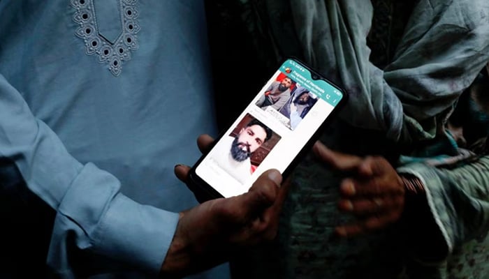 A family member shows a mobile phone with a picture of Muhammad Nadeem, 38, father of three sons, who along with others died when a migrant boat shipwrecked off the coast near Benghazi in Libya, outside his family home in Hariyawala town in Gujrat district of Punjab province, Pakistan March 3, 2023. — Reuters