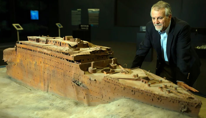 Paul-Henry Nargeolet poses next to a miniature version of the sunken Titanic at The Paris Expo on May 31, 2013. — AFP