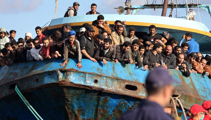 Rescued refugees and migrants stand aboard a boat at the town of Paleochora, southwestern Crete, on 22 November 2022. — AFP