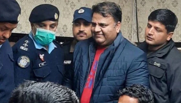 Former information minister Fawad Chaudhry (C) smiles while police officials escort him after a hearing at a court in Islamabad. — AFP/File