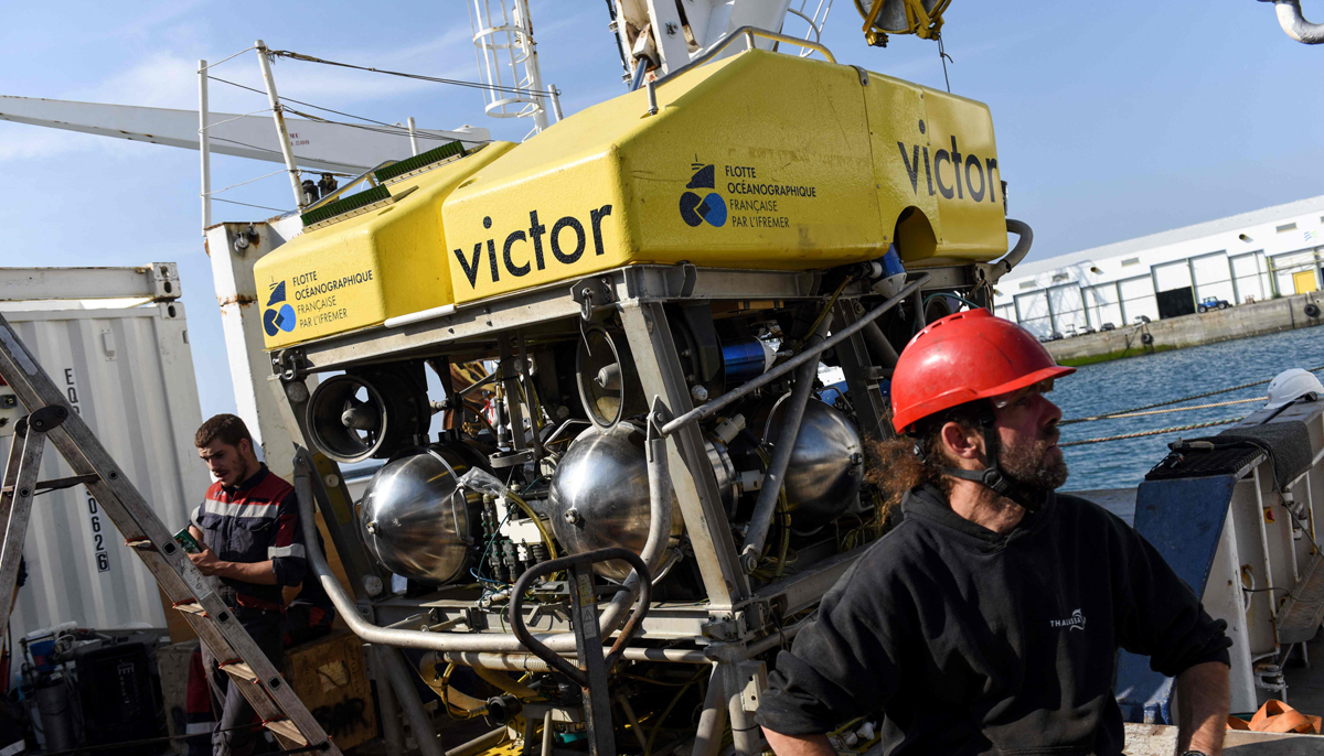 A worker sits near the underwater robot Victor onboard the Thalassa, the ship of French Research Institute for the Exploitation of the Sea (IFREMER), moored at Brest harbour, western France, on August 31, 2022. — AFP