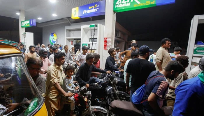 People wait for their turn to get fuel at a petrol station in Peshawar, January 30, 2023. — Reuters