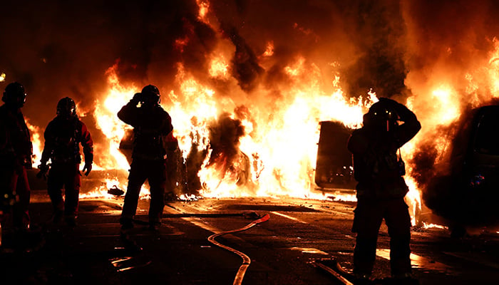 Firefighters stand as they extinguish burning vehicles during clashes between protesters and police, after the death of Nahel, a 17-year-old teenager killed by a French police officer during a traffic stop, in Nanterre, Paris suburb, France, June 28, 2023. — Reuters