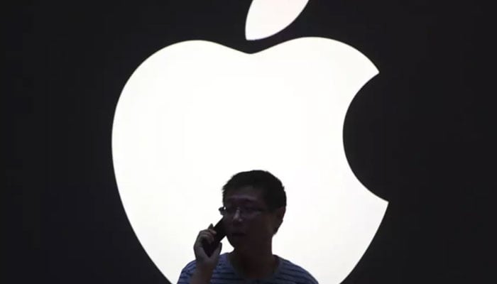 A man talks on a mobile phone in front of an Apple logo outside an Apple store in downtown Shanghai on September 3, 2012. — Reuters