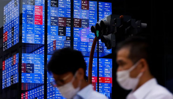 People pass by an electronic screen showing Japans Nikkei share price index inside a conference hall in Tokyo, Japan on June 14, 2022. — Reuters