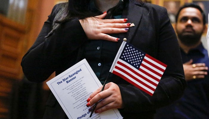 An immigrant is seen holding American flag. AFP/File
