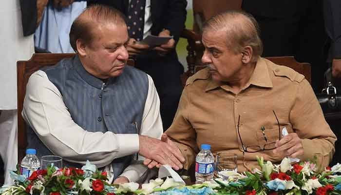 PML-N supremo Nawaz Sharif (left) shakes hands with Prime Minister Shehbaz Sharif. — AFP/File